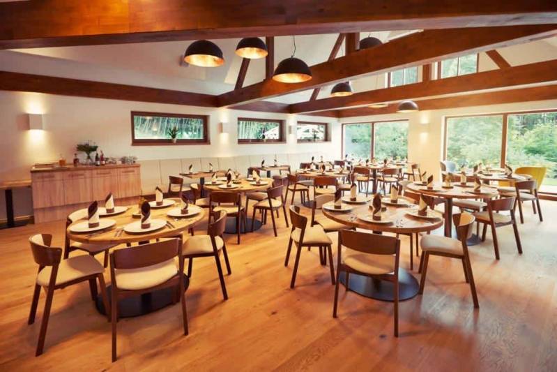 Na kraji lesa - Interiéru restaurace dominují velké dubové stoly a výhledy do krajiny